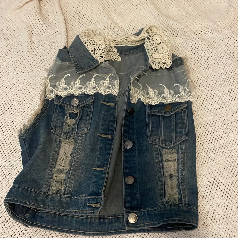 Cute laced denim vest. No size listed but I’d say a small.